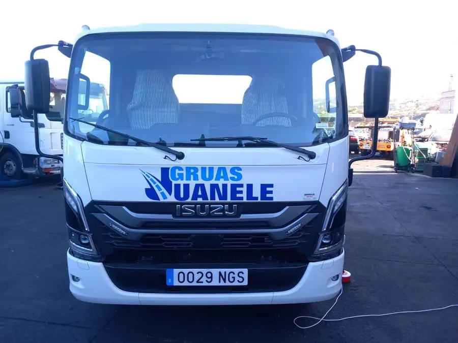 Vista frontal de un camión Isuzu de Grúas Juanele en sus instalaciones